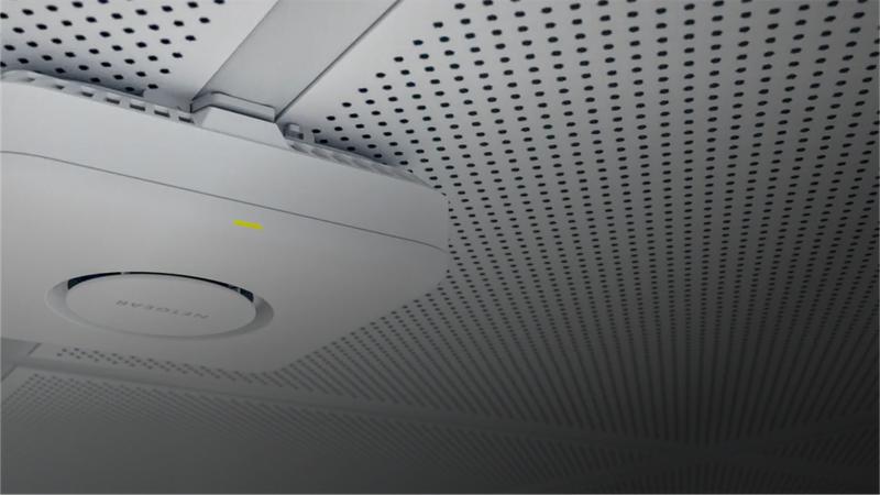 NETGEAR WiFi 7 access point mounted on an office ceiling
