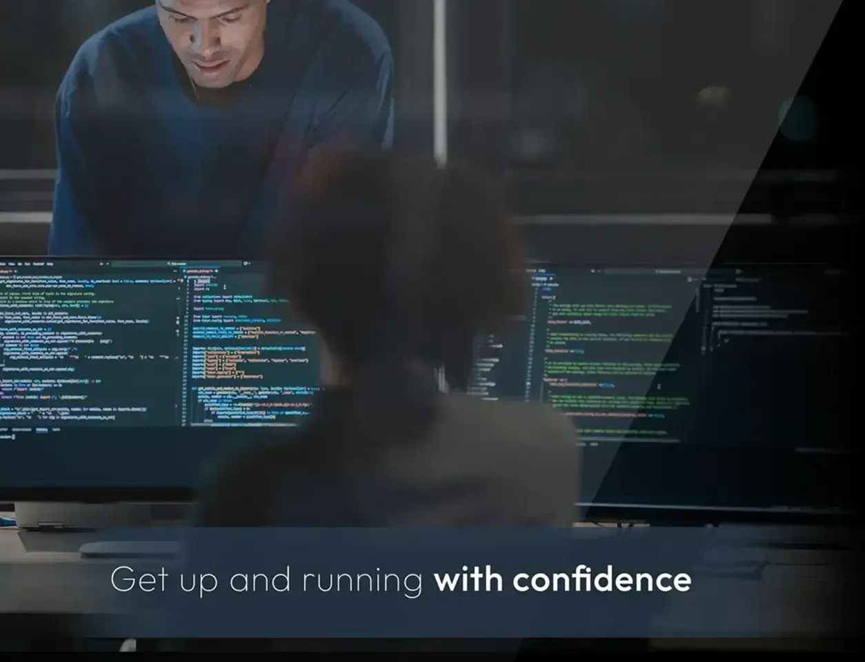 Two IT professionals working at monitors full of code, with the words Get up and running with confidence