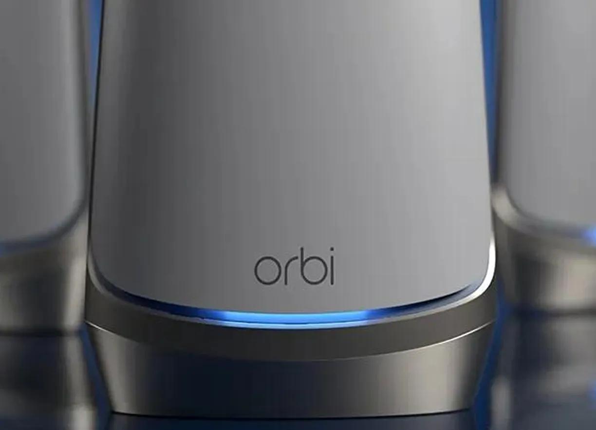 Close-up of an Orbi mesh WiFi unit with its blue light ring glowing