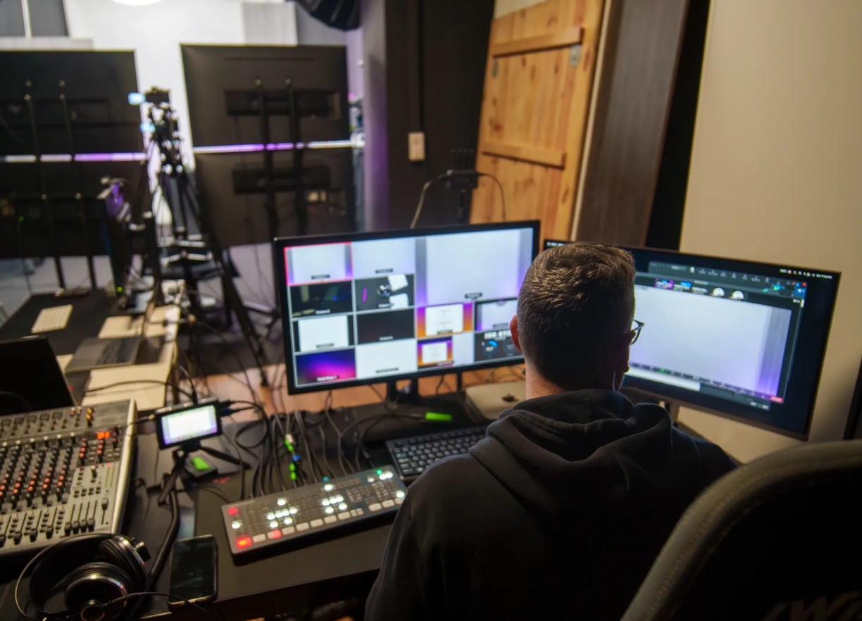 Rear view of adult Hispanic man TV editor working in television studio